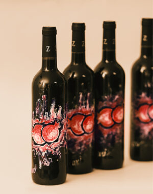 בקבוק יין עם ציור רימון בצבע אדום לבן, קו גבולות הציור בחריטה בתוך משטח הצבע, המחבר את הצופה בצורה טבעית בין מתיקות הרימון - לניחוח היין, להרגשה מושלמת ונעימה.